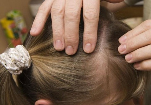 manos tocando el pelo de una niña